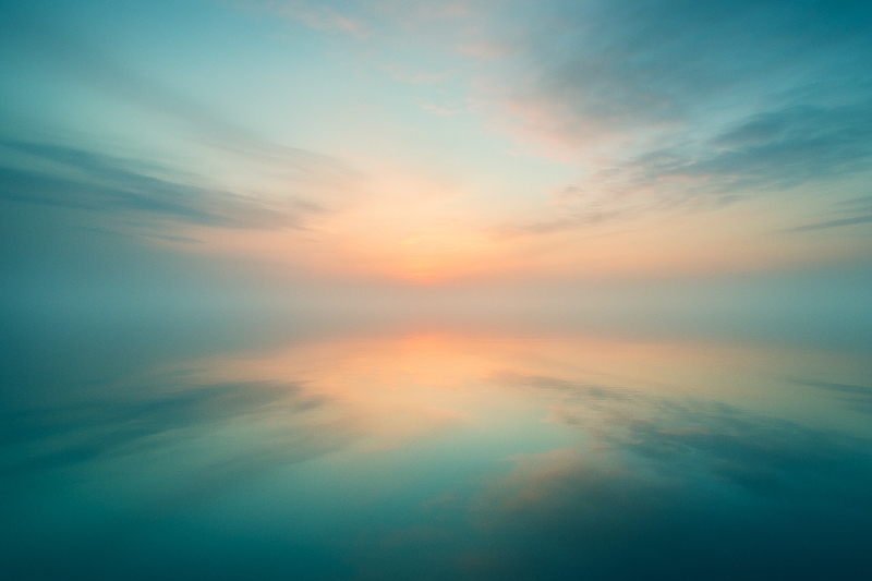 A serene abstract landscape symbolizing the boundary between this world and the other shore, with soft light reflecting over calm water.