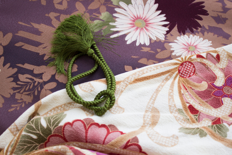 A close-up of kimono fabrics with floral patterns, showing colors associated with different seasons.