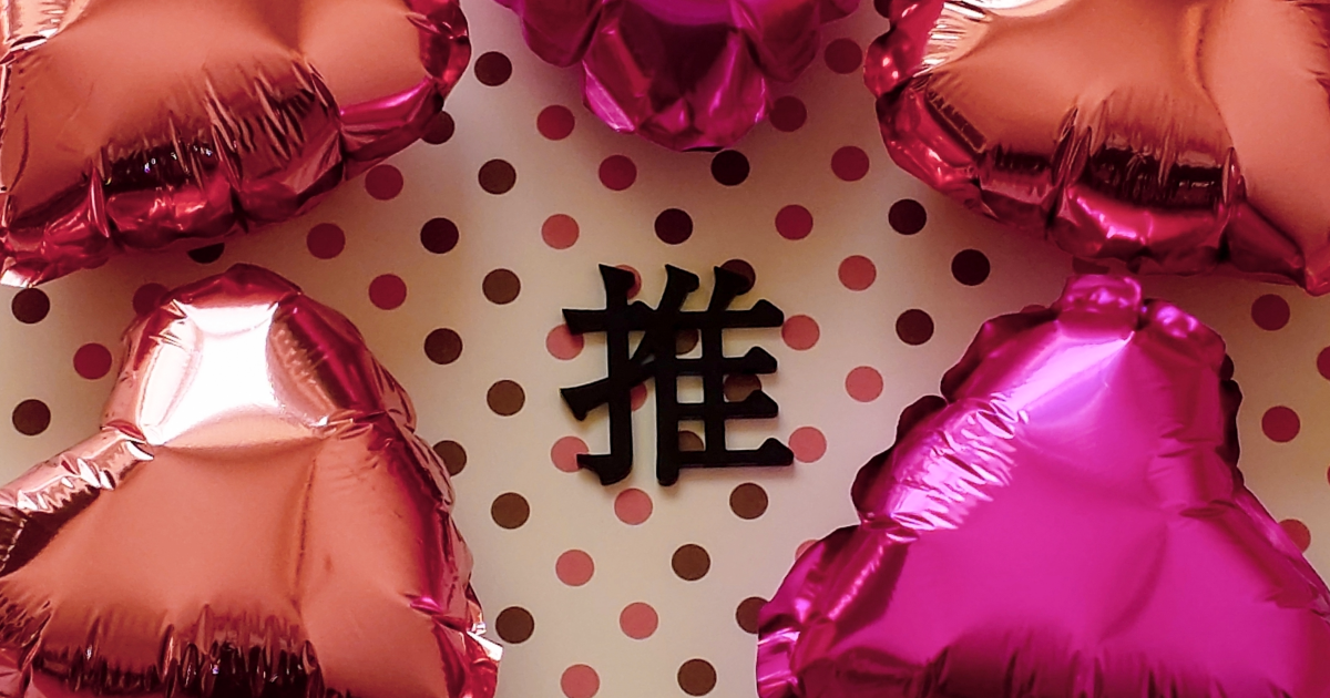 Pink heart balloons surrounding the character for ‘oshi,’ representing oshikatsu culture